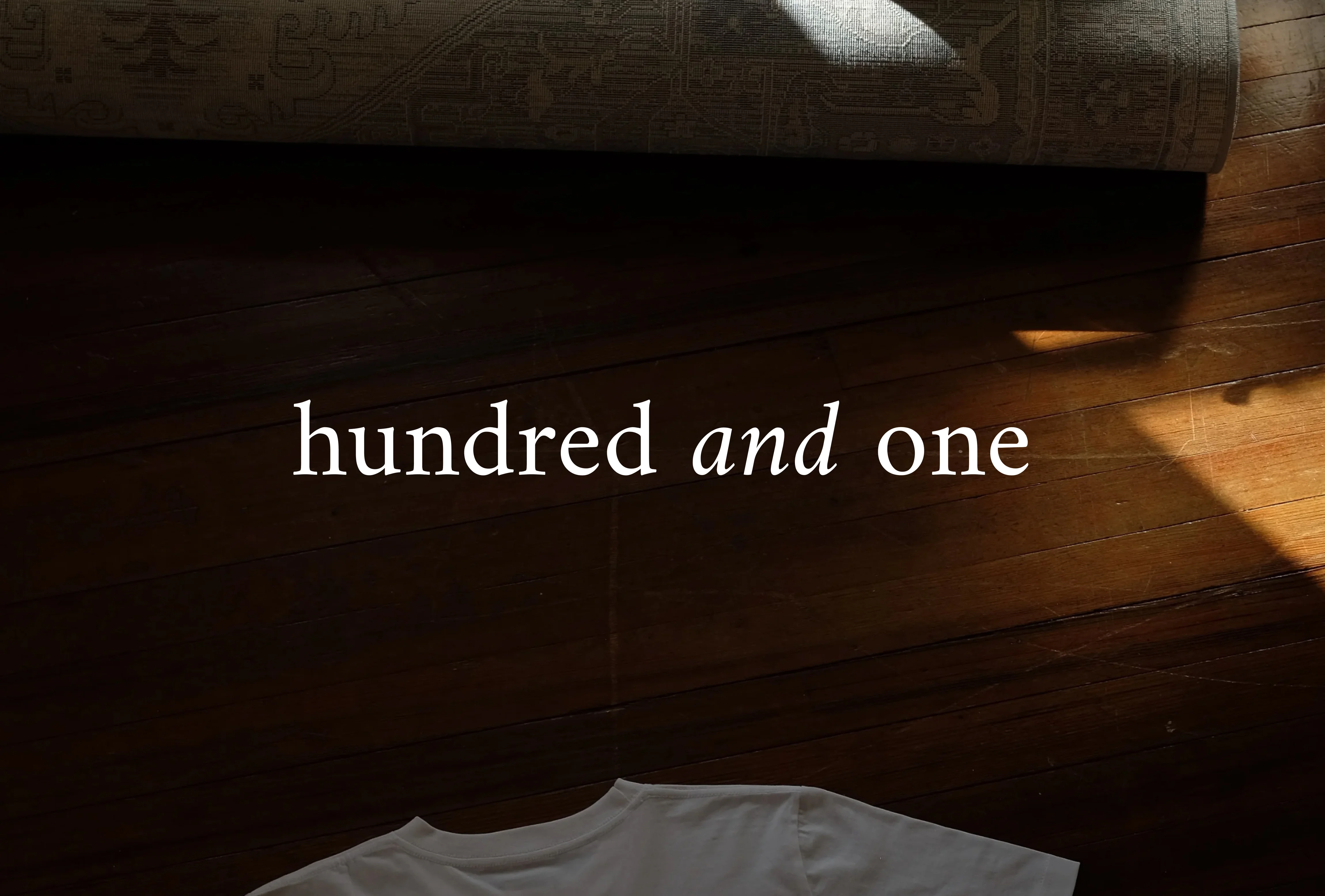 hundred and one brand image,white tee on wooden floor with warm light